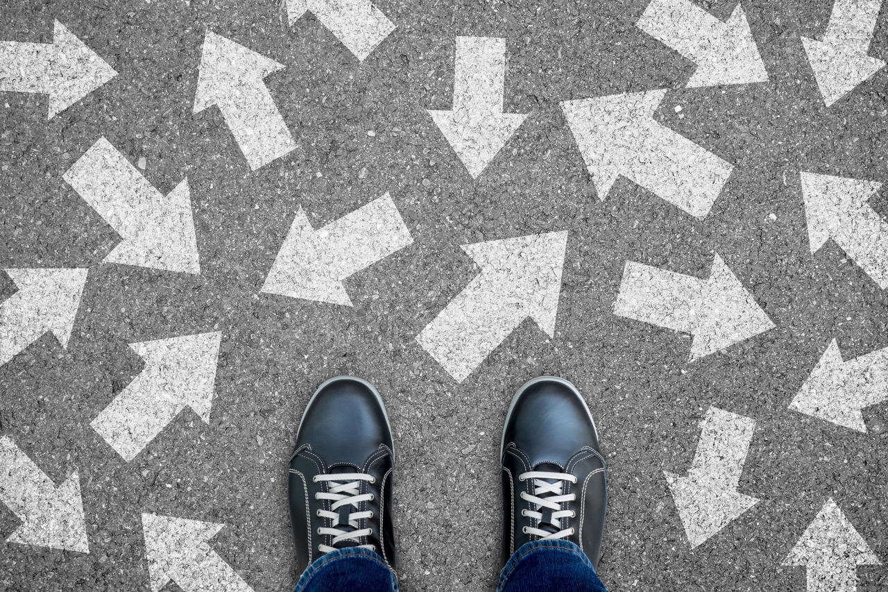 Feet standing on arrows pointing in different directions, symbolizing multiple relocation choices